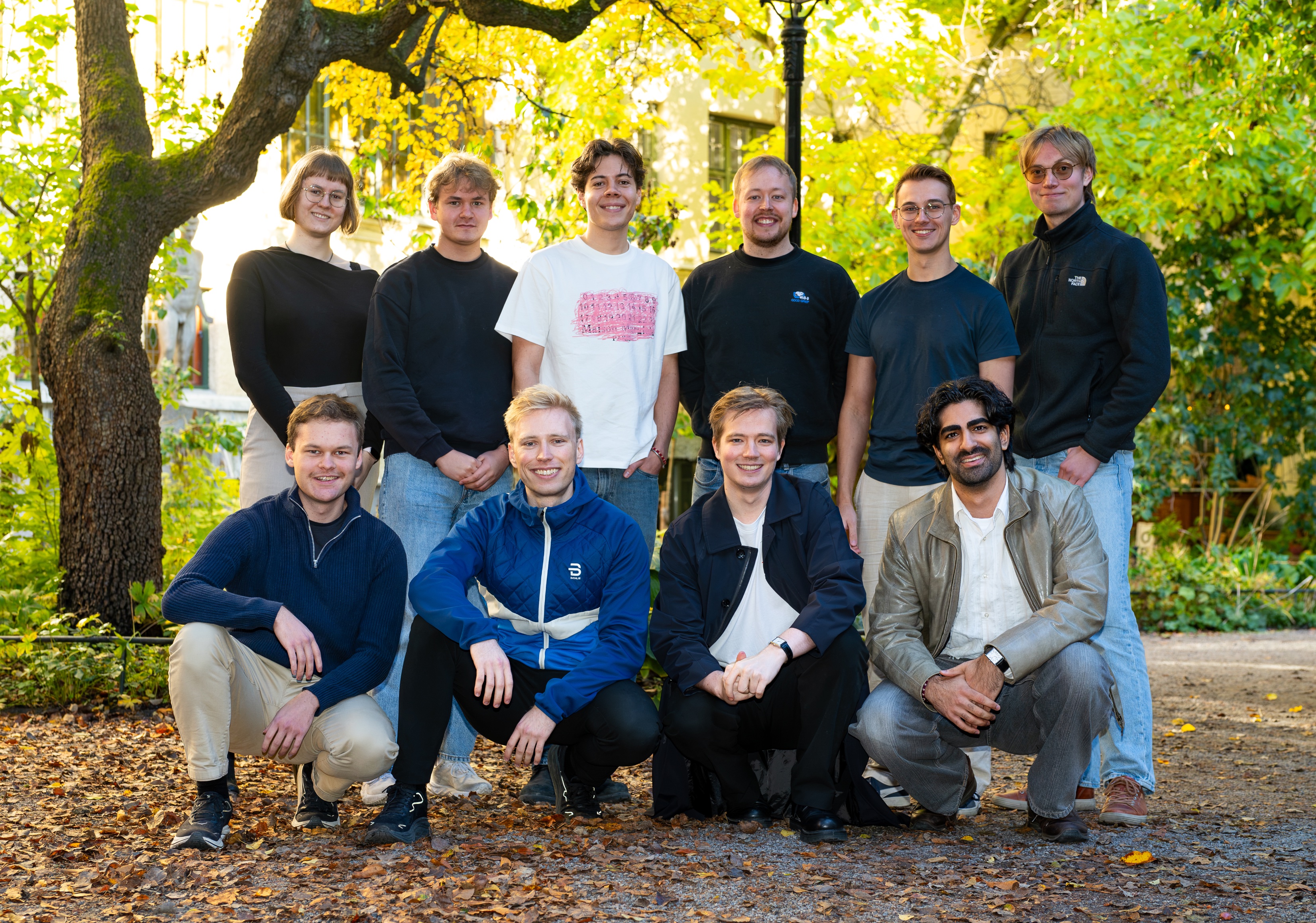 The Strawberry team, ten people outdoors under autumn trees.